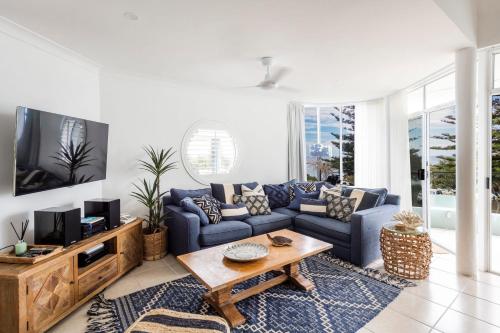 a living room with a blue couch and a tv at La Ronde Three - Unit 3 - Oceanstays in Yamba