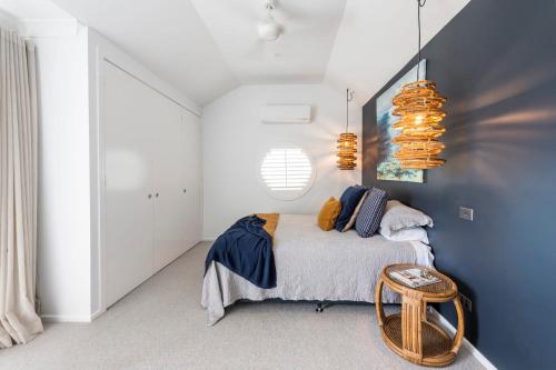 a bedroom with a bed with a blue wall at La Ronde Three - Unit 3 - Oceanstays in Yamba