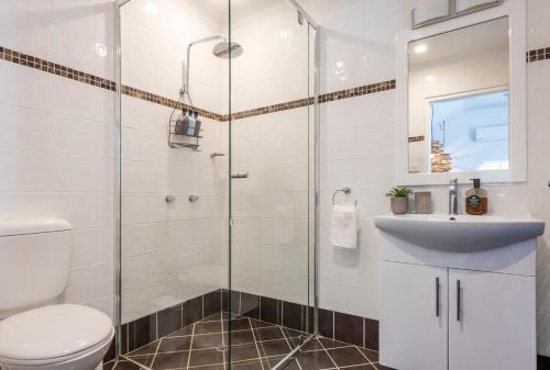 a bathroom with a shower and a toilet and a sink at La Ronde Three - Unit 3 - Oceanstays in Yamba