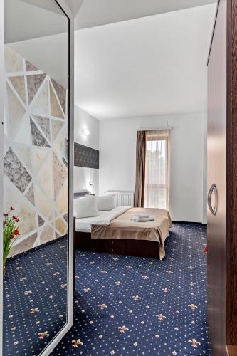 a hotel room with a bed and a mirror at Hotel Charter Otopeni in Otopeni