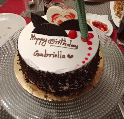 a birthday cake with a candle on a table at Club De Novo Hotel in Butwāl