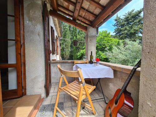 Il Casale Delle Farfalle في سيرولو: طاولة و غيتار على شرفة المنزل