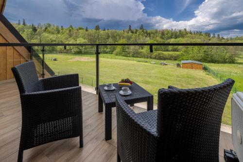 a patio with two chairs and a table on a balcony at Aparthotel Góralski Spa 2 in Białka Tatrzanska