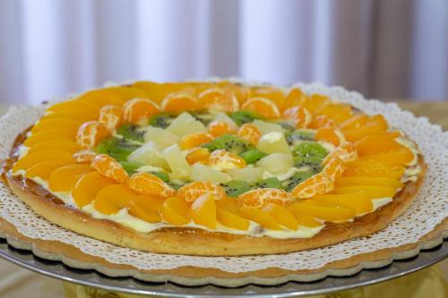 a cake with oranges and vegetables on a plate at Villa Zina Family Resort in Custonaci