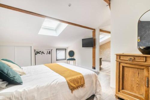 um quarto com uma cama grande e uma cómoda em madeira em Le Loft Bergeracois em Bergerac