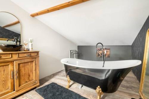 a bathroom with a black tub and a sink at Le Loft Bergeracois in Bergerac