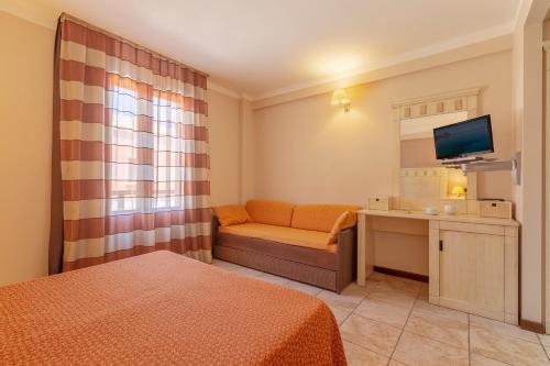 a hotel room with a bed and a couch and a television at Villa Zina Family Resort in Custonaci
