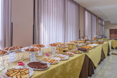 a row of tables filled with different types of food at Villa Zina Family Resort in Custonaci