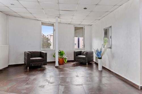 an empty waiting room with two chairs and flowers at Hotel Charter Otopeni in Otopeni