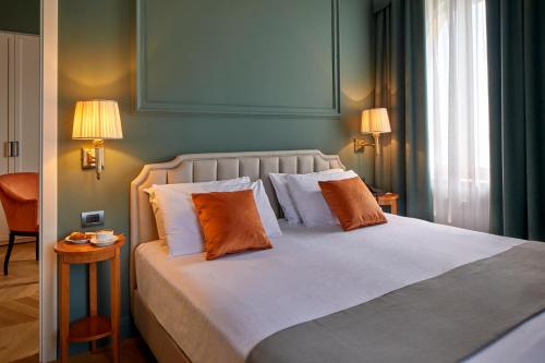 a bedroom with a large bed with two pillows at Hotel Villa Del Sogno in Gardone Riviera