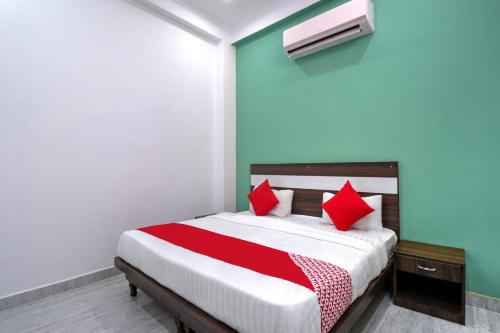 um quarto com uma cama com almofadas vermelhas em OYO 71370 White House em Garhi Harsāru