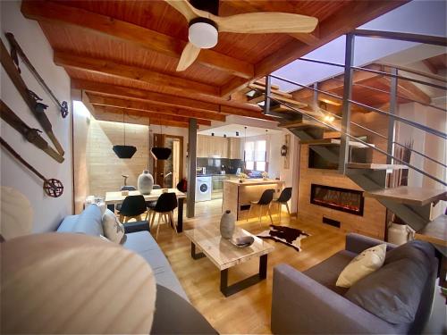 ein Wohnzimmer mit einem Sofa und einem Tisch in der Unterkunft CAL DOMÈNEC - Dúplex lujo en Rialp ( Se admiten mascotas) in Rialp