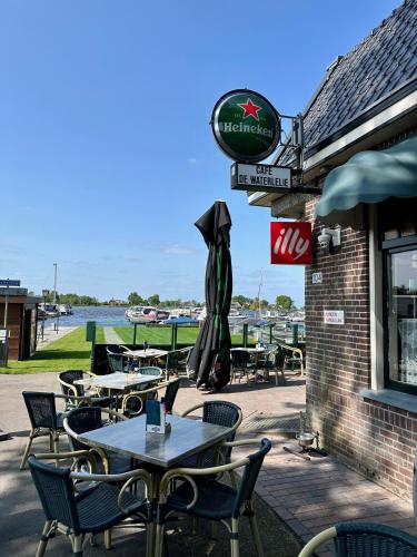 a group of tables and chairs in front of a restaurant at LODGE, een super knus tiny house, nabij vaarwater en haven! in Belt-Schutsloot