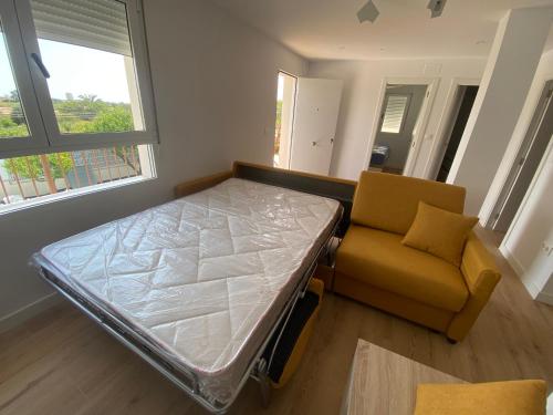 una cama de hospital y un sofá en una habitación en vistalmar 1 casa verde en San Juan de Alicante