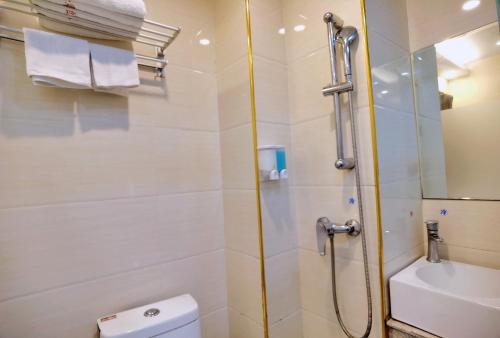 a bathroom with a shower and a toilet and a sink at Songyuan Hotel 松缘酒店 in Shenzhen