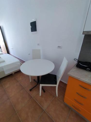 a white table and a chair in a room at ARTEMISA APARTMENTS in Vlorë