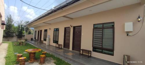 - un bâtiment avec une terrasse dotée d'une table et de bancs dans l'établissement Comfy room in Gunung Ledang, 