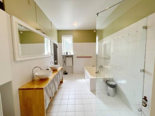 ein Badezimmer mit zwei Waschbecken, einer Badewanne und einer Dusche in der Unterkunft Spacious apartment in city center in Tallinn
