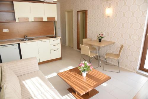 Hotel Paradise Garden في تشيرنوموريتس: غرفة معيشة مع طاولة ومطبخ