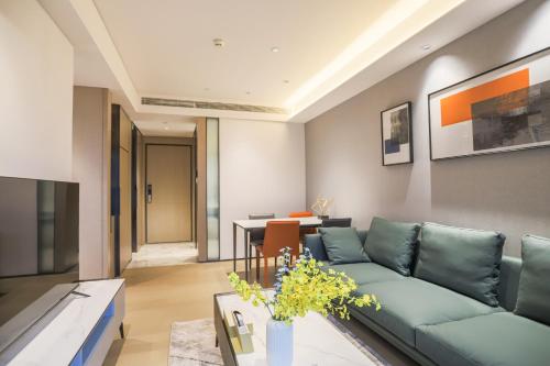 a living room with a blue couch and a table at Canopy Executive Apartments - Shenzhen Futian Center in Shenzhen