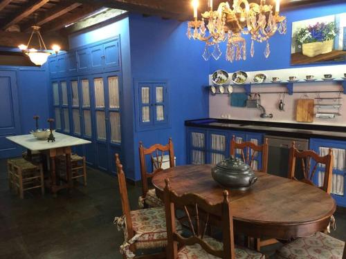 une salle à manger avec une table et un mur bleu dans l'établissement Casa rural con piscina privada, à Casar de Palomero