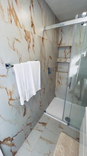 a bathroom with a glass shower and white towels at Cozy Charming Bungalow BRAND NEW in Preston