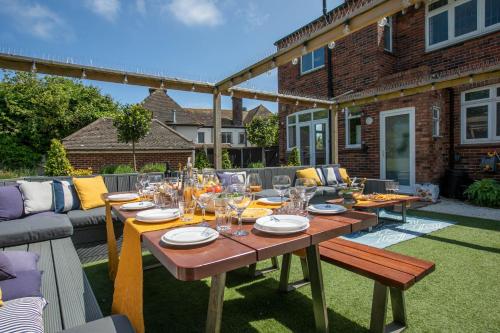 a wooden table with wine glasses on a patio at Winterstoke View-Family&Dog Friendly Beach Retreat in Ramsgate
