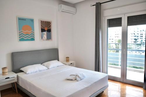 una camera da letto con un letto e un asciugamano sopra di SynPiraeus Apartments & Studios a Pireo