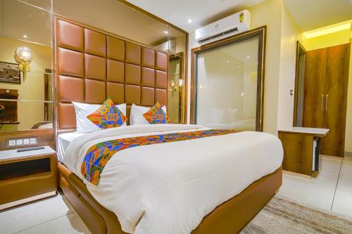 a bedroom with a large bed with a large headboard at FabHotel Benchmark in Indore