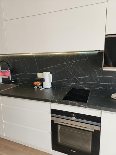 a kitchen counter with a black counter top at Prie Vilneles Apartment in Vilnius