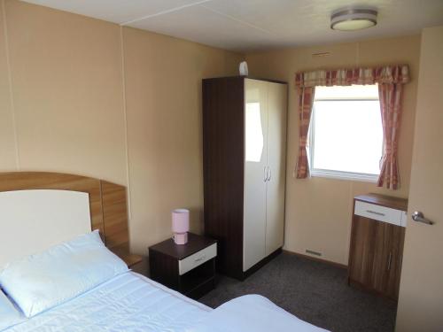 a hotel room with a bed and a window at Highfield and Haven : Elegance:- 4 Berth Central Heated in Lincolnshire