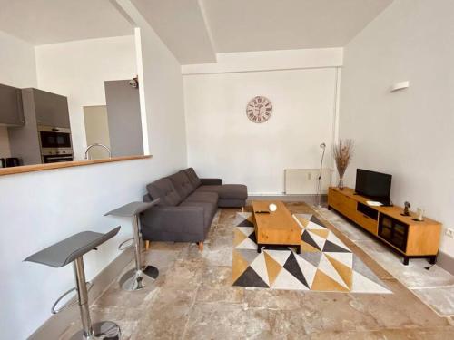 un soggiorno con divano e tavolo di Appartement dans belle résidence Semuroise a Semur-en-Auxois