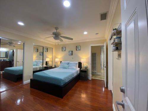 ein Schlafzimmer mit zwei Betten und einem Deckenventilator in der Unterkunft Huntington Beach adorable 2 bedrooms, 2 bathrooms in Huntington Beach