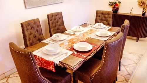 einem Esstisch mit Stühlen und einer Tischdecke darauf in der Unterkunft Ruby and Pearl by Flair Apartments in Lagos