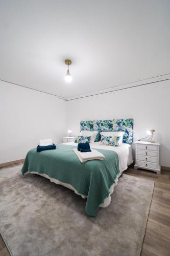 a bedroom with a large bed with a green blanket at Casa Milita in São João da Pesqueira