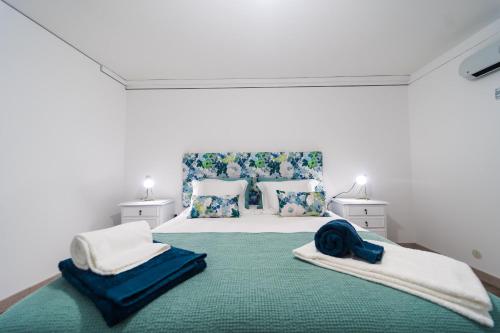 een slaapkamer met een groot bed met blauwe en witte kussens bij Casa Milita in São João da Pesqueira