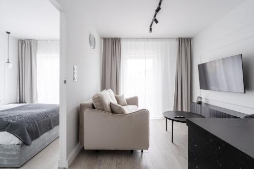 a bedroom with a bed and a chair and a table at RentPlanet - Atal City Square in Wrocław