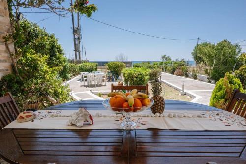 a table with a bowl of fruit on top of it at Villa Kyma by the sea, in South Crete in Keratokampos
