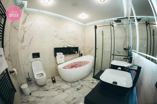 a bathroom with a bath tub and a sink at Adria centar Koćuša in Ljubuški