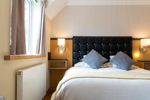 een slaapkamer met een groot bed met blauwe kussens bij The Regent, Rye in Rye