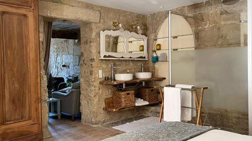 La salle de bains est pourvue d'un lavabo et d'un mur en pierre. dans l'établissement Mas Saint-Genies, à Venasque