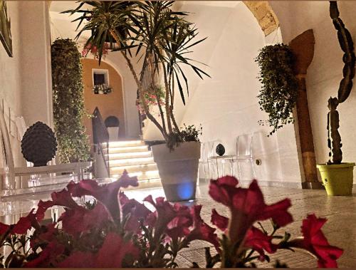a room with flowers and potted plants and stairs at B&B Palazzo Diaz in Marsala