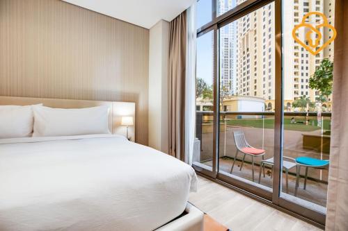 um quarto com uma cama e uma grande janela em Keysplease Beachside Studio Minutes to the Beach & The Walk, JBR P50A em Dubai