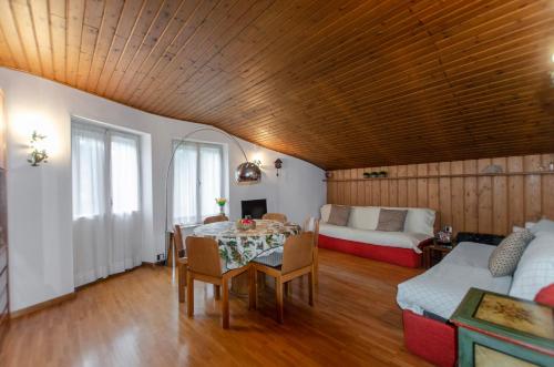 een woonkamer met een tafel en een bank bij Spazioso appartamento centrale con wi-fi in Cortina dʼAmpezzo
