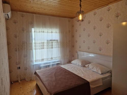 a small bedroom with a bed and a window at Mountain Resort House in Gabala
