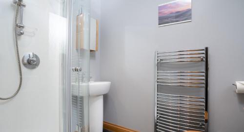 a bathroom with a sink and a shower at Salmon Run Lodge in Carrbridge