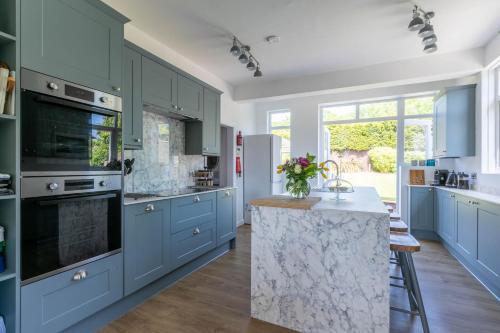 een keuken met blauwe kasten en een marmeren aanrecht bij Winterstoke View-Family&Dog Friendly Beach Retreat in Ramsgate