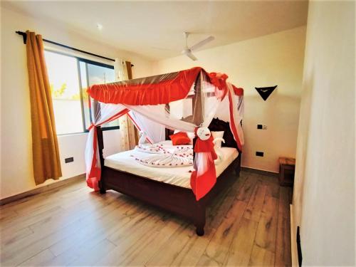 - une chambre avec un lit à baldaquin dans l'établissement V-Szameitat Homes, Kongo River, à Diani Beach