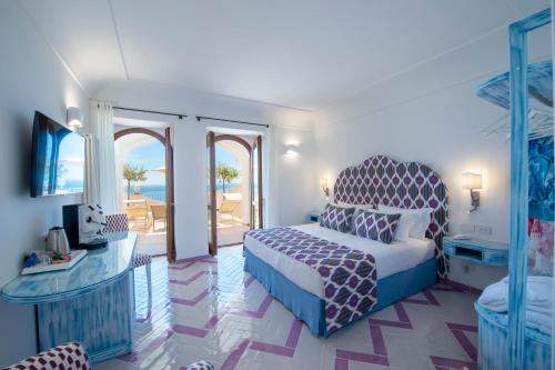 a bedroom with a bed and a balcony with the ocean at Hotel Il Gabbiano in Positano