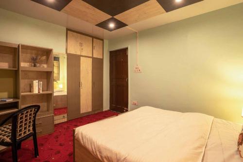 a bedroom with a bed and a desk and a chair at StayVista at Lavender Haze - 3BR Cottage in Pahalgām
